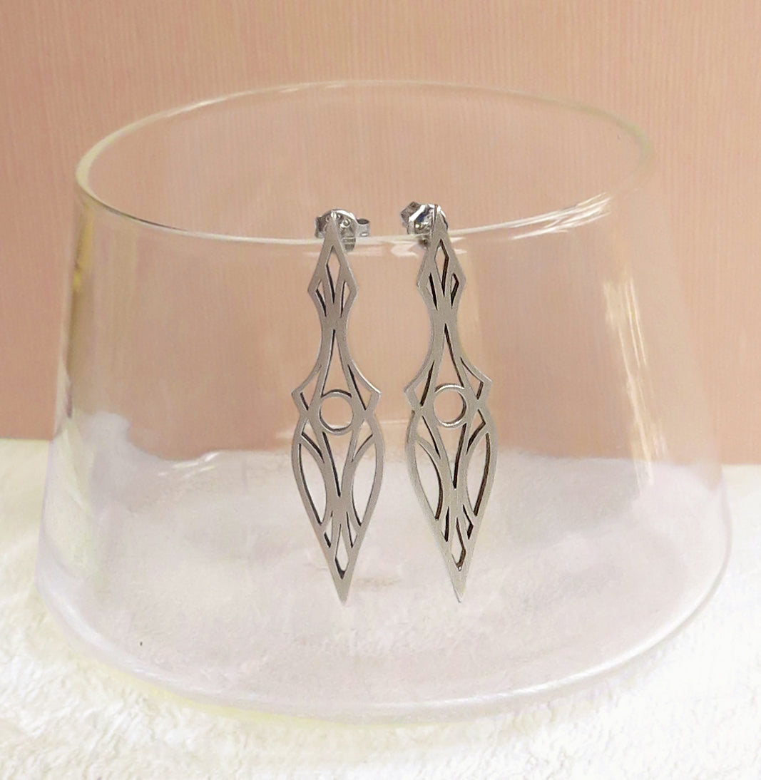 Art deco dagger stud earrings. Made of brushed sterling silver and oxidized for contrast. Hanging on a glass.