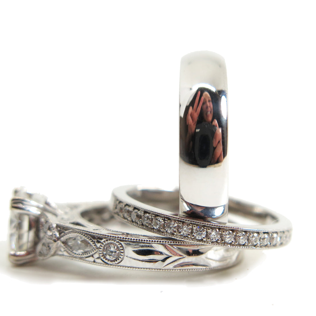 A sparkling wedding set with a person reflection in the wedding band