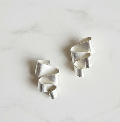 Sterling silver meandering ribbon earrings against a white background