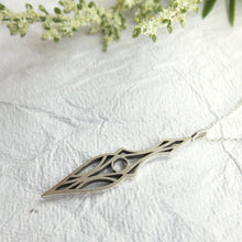 Load image into Gallery viewer, Geometric and symmetrical art deco dagger pendant necklace. Made of brushed sterling silver and oxidized for contrast. On a textured white paper background.
