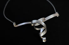 Load image into Gallery viewer, An elegant and modern matte finish sterling silver double whirl ribbon necklace on a silver chain.
