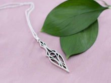 Load image into Gallery viewer, Sterling silver geometric art deco dagger pendant necklace  on a pink background with leaves

