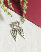 Load image into Gallery viewer, Sterling silver art deco geometric teardrop stud earrings with cubic zirconia gemstones on a white and red textured paper background with sprigs of flowers.
